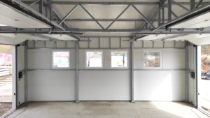 10x10m-es delux szigetelt mobilgarázs, fehér színben, jobbra lejtő tetővel, 4db szekcionált kapuval, 4db ablakkal, szegélyekkel, ereszcsatonával, horganyzott vázszerkezettel
